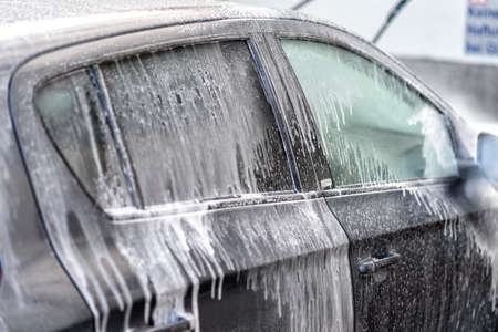 washing a car at the car wash with water and shampooの写真素材