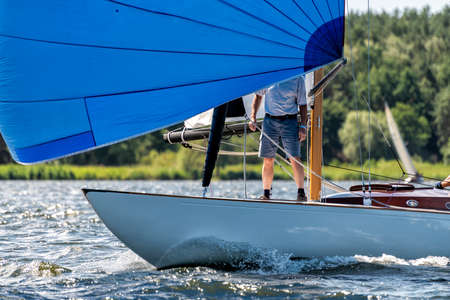 classic sailing yacht sailing with spinnaker on a lake during a regatta