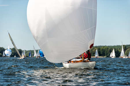 classic sailing yacht sailing with spinnaker on a lake during a regatta