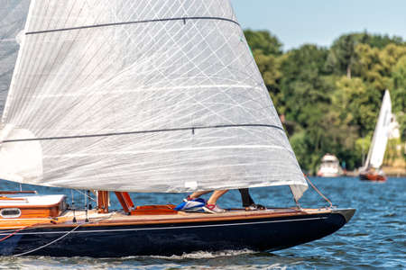 classic sailing yacht sailing with spinnaker on a lake during a regatta