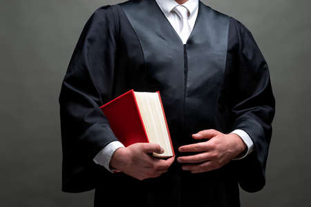 german lawyer with a classical black robe, white tie and book