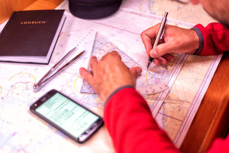 navigation with sea charts in the chart room on a sailing yacht