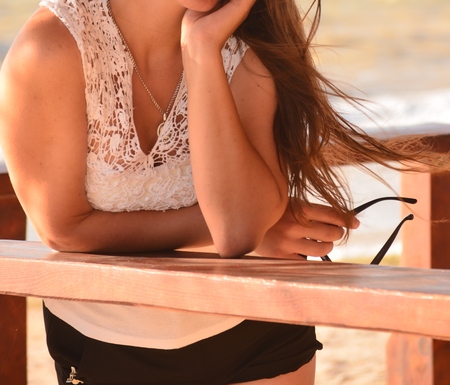 Young beautiful woman poses for a girl on a sea summer photo shootの写真素材