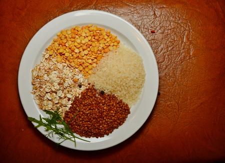 on a white plate and a dark brown background buckwheat porridge rice peas and Dill rakula copy spaceの写真素材
