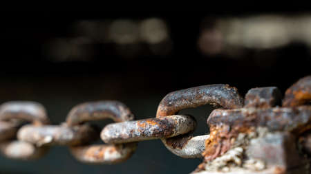 rusty chain in horizontal closeup isolated with unfocused backgroundの写真素材