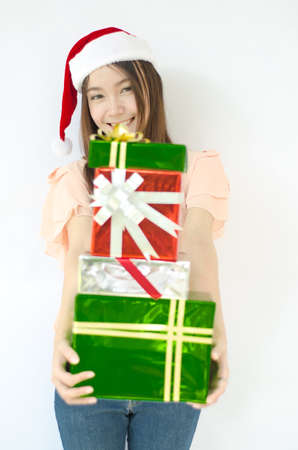 Santa woman showing gift wearing Santa hat  Christmas woman portrait of a cute, beautiful smiling...