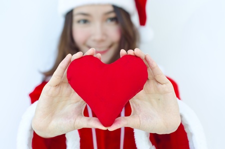 A Beautiful Asian santa woman in red cloth with red heart in her handの写真素材
