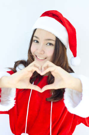 A portrait of beautiful Asian Santa woman making heart sign の写真素材