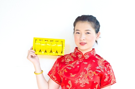 chinese woman wear cheongsam and holding gold ingotの写真素材