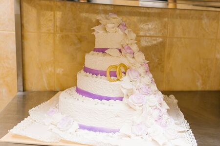 wedding dessert, beautiful cake with lilac color and stylized wedding rings for the bride and groomの写真素材