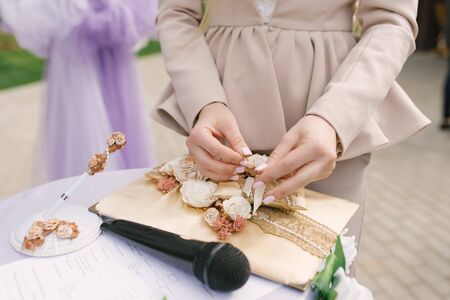 The wedding planner puts the wedding rings on the pillow. The ceremony of marriageの写真素材