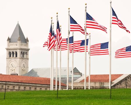 Ring of flags surrounding the Washington Monument with the Old Post Office clock tower in the background.のeditorial素材