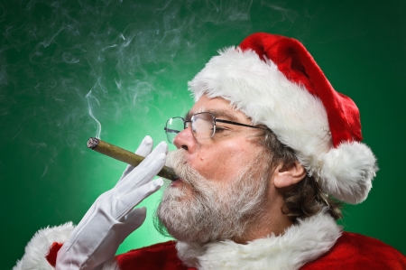A bad Santa smoking a cigar.の写真素材