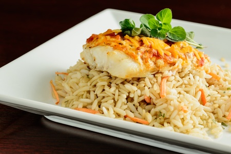 Grilled tilapi topped with marinara and cheddar cheese, garnished with oregano.の写真素材