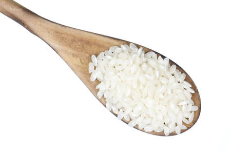Closeup overview of rice in a wooden spoonの写真素材