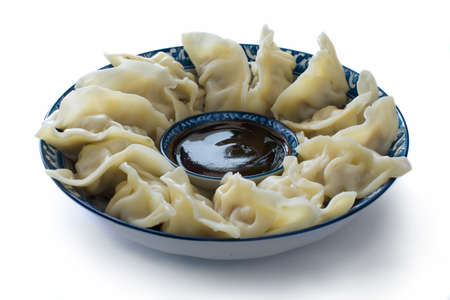 Closeup of a dish of dumplings with dipping sauceの写真素材