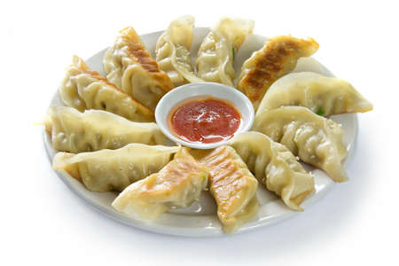 Closeup of a dish of dumplings with dipping sauceの写真素材