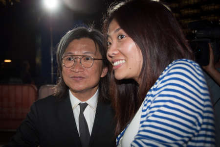 TORONTO - SEPTEMBER 10  Director Peter Chan Ho-sun takes a photo with fan at the Toronto International Film Festival for his film  American Dreams in China on September 10, 2013 のeditorial素材