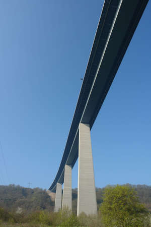 A high bridge connecting two mountain tops against blue skyの写真素材