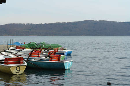 Different brightly colored rental boats at a large lakeの写真素材