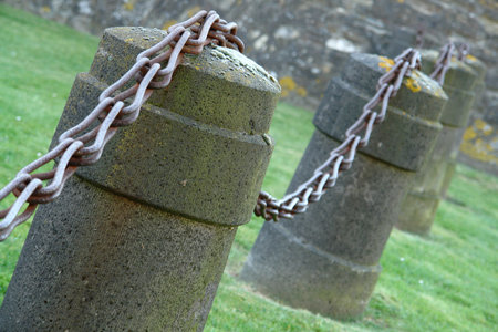 Fence of a castle with huge chains and stone pillarsの写真素材