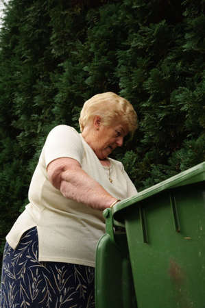 Senior woman with a passion for gardening working in her lovely gardenの写真素材
