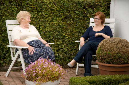 senior woman chatting outside with her redhead granddaughterの写真素材
