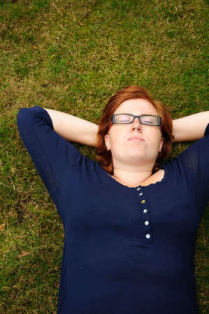 Beautiful young woman relaxing in the grassの写真素材