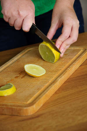 Lemon on cutting board with knifeの写真素材