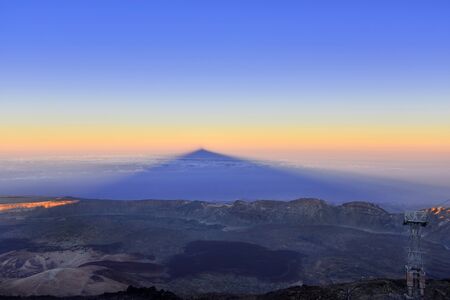 Sunset at the top of the volcano Teide, in Tenerife (Canary Is), casting its shadow on the lava...