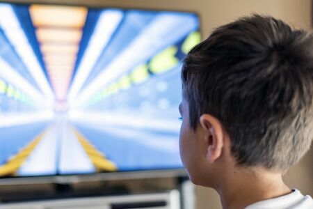 Boy watching his favorite show on TVの写真素材