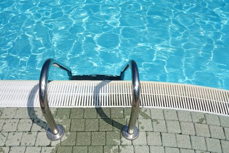 Ladder for entering in a crystal clear blue swimming poolの写真素材