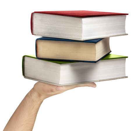 Hand holding stack of colorful hard cover books isolatedの写真素材