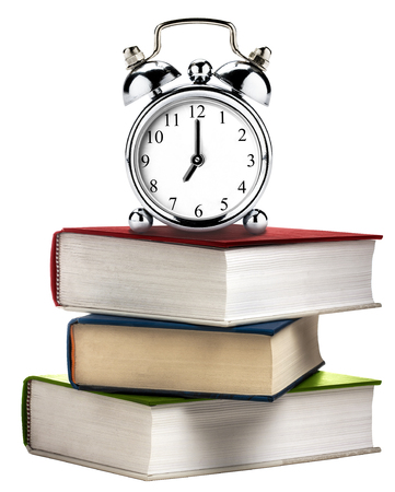 Vintage clock alarm on stack of books isolated on whiteの写真素材
