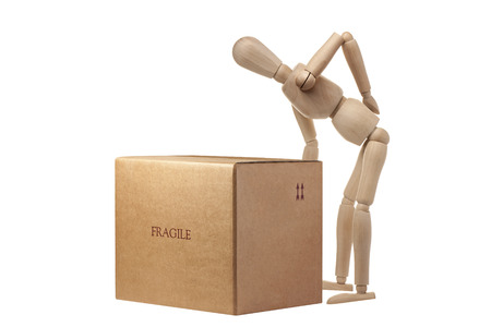 Wooden Mannequin having an accident carrying box isolatedの写真素材