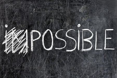 Impossible Becomes possible handwritten with white chalk on blackboard dirtyの写真素材
