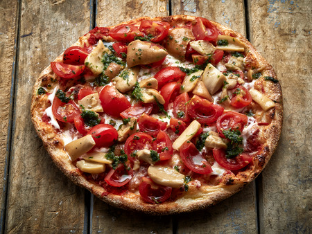 Pizza with mushrooms and tomatoesの写真素材