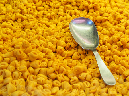 Raw Tortellini italian pasta with spoon at marketの写真素材