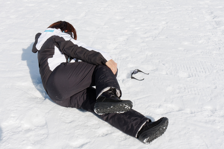 Young woman injured on the snow feeling painの写真素材