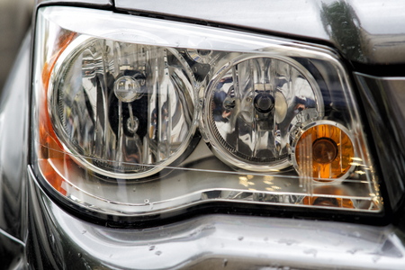 Headlight closeup of grey sporty carの写真素材