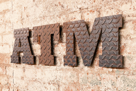 ATM rusty metal sign on the wallの写真素材