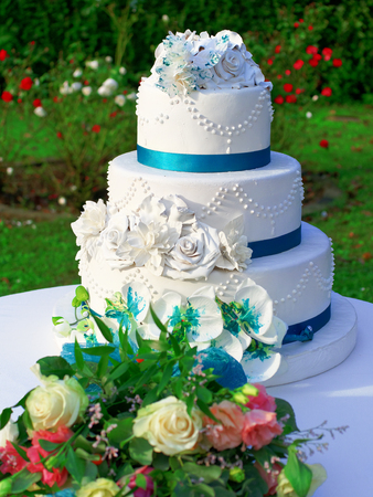 Wedding cake decorated with flowers outdoorの写真素材