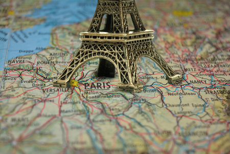 Small Eiffel tower Paris souvenir closeup on mapの写真素材