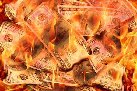 Dollars Banknotes or bills of United States of America dollars burning in flame concept of crisis, loss, recession or failure