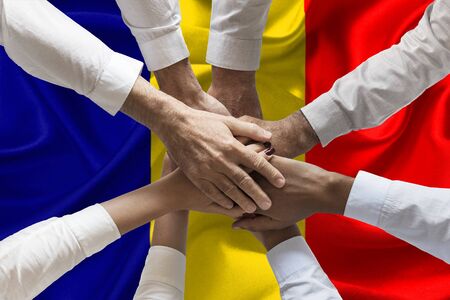 Union or Team Hands multcultural people team over romanian flag topviewの写真素材