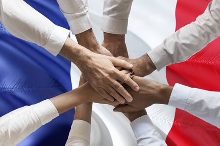 Hands multcultural people team over french flag topviewの写真素材