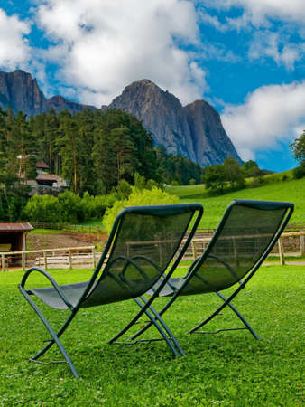 two vacant deckchairs admiring mountain landscape in summerの写真素材