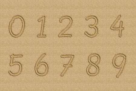 Numbers written in sand on a beach.の写真素材