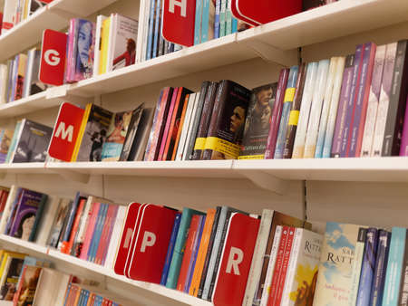 Milan, Italy - 2019 August: Shelves of books on sale at modern bookshopのeditorial素材