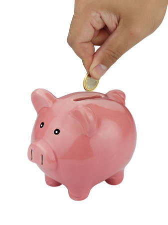 closeup of man hand inserting coin into piggybank isolated on whiteの写真素材